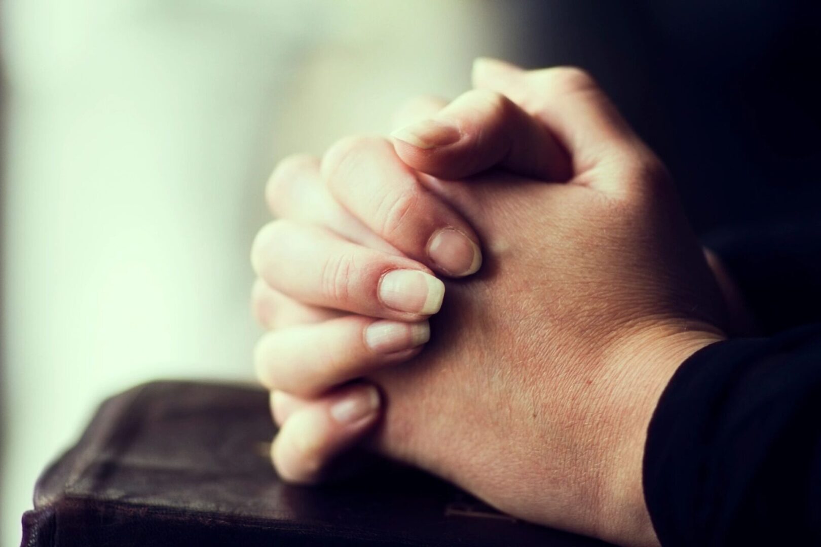 A pair of hands with long nails clasped together in prayer A pair of hands with long nails clasped together in prayer