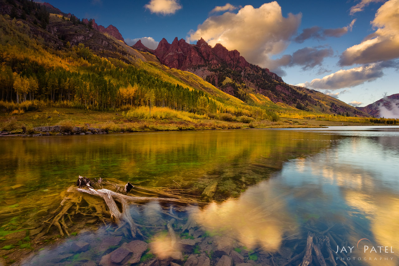 Autumn mountains reflected in a calm lake under a vibrant sky. Autumn mountains reflected in a calm lake under a vibrant sky.