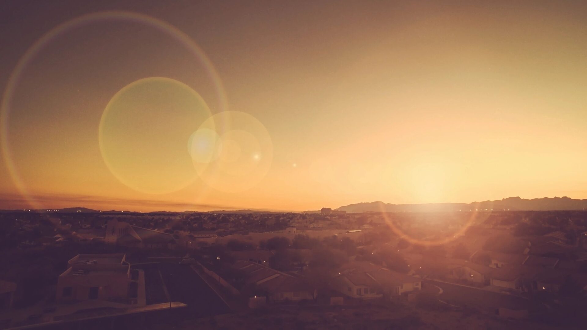 Sunset over a serene desert landscape with sun flare. Sunset over a serene desert landscape with sun flare.