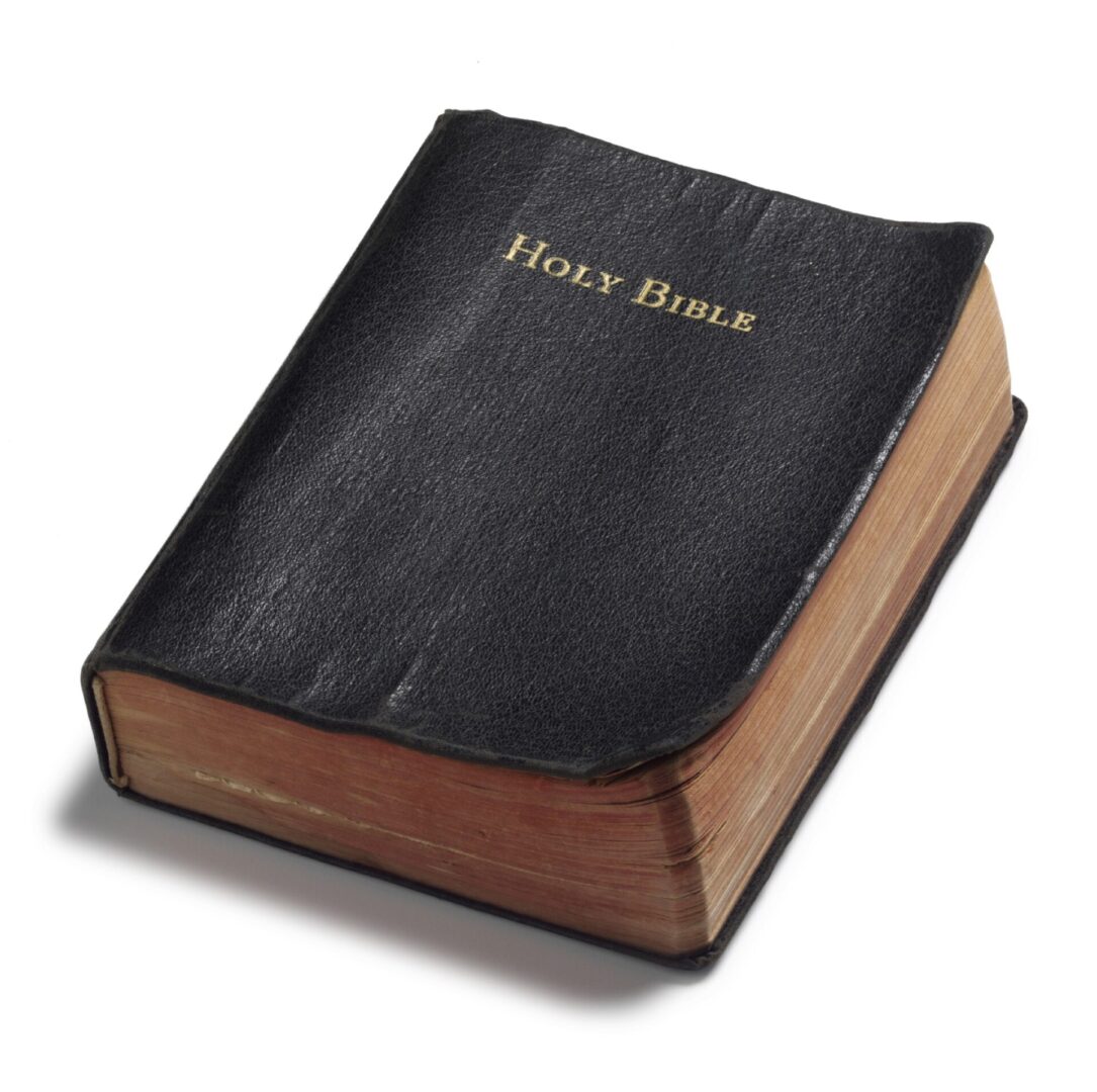 A closed black leather-bound Holy Bible with gold-edged pages. A closed black leather-bound Holy Bible with gold-edged pages.