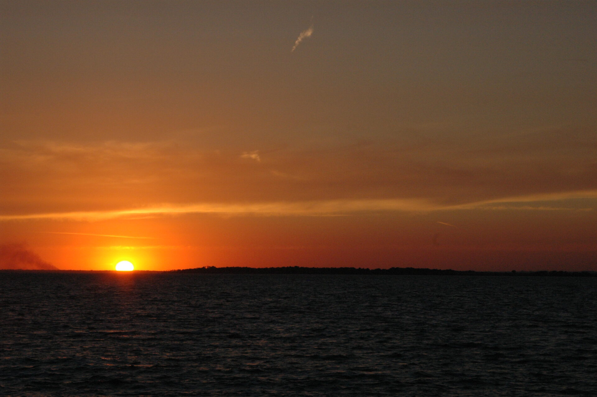 Sunset over calm ocean waters with a clear sky. Sunset over calm ocean waters with a clear sky.